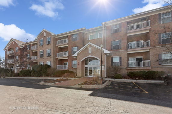 Front view of a multi-story brick building with balconies.