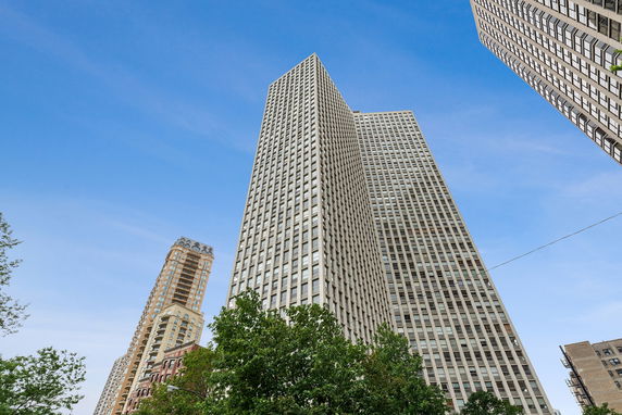 Front view of tall skyscrapers against a blue sky.