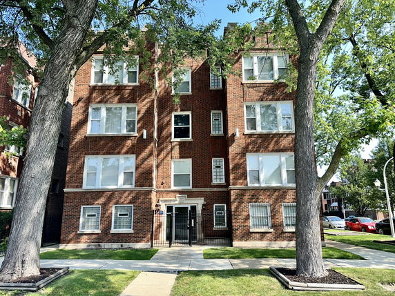 Front view of a multi-story brick apartment building.