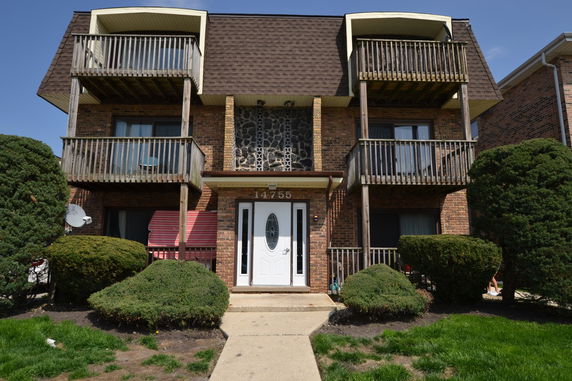 Front view of a multi-story brick building with balconies.