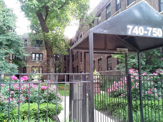 Front view of a brick residential building with a gated entrance.