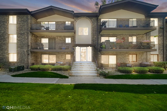 Front view of a multi-story apartment building with balconies.