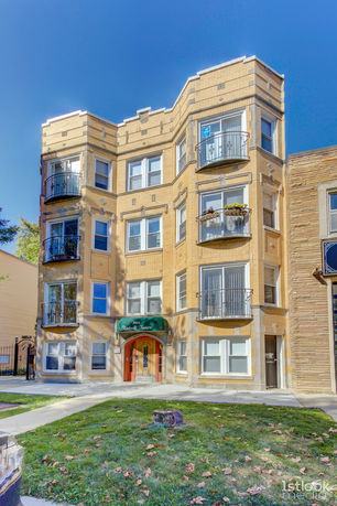 Front view of a multi-story brick apartment building with multiple balconies.