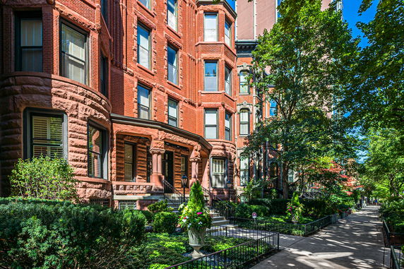 Front view of a historic multi-story brick building with detailed stonework.