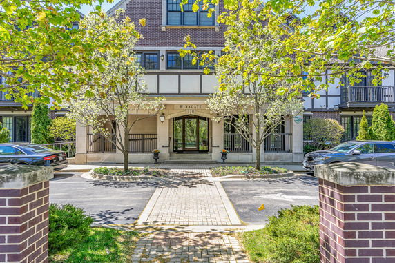 Front view of a multi-story building with a brick facade and driveway.