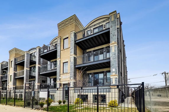 Front view of a multi-story apartment building with balconies.