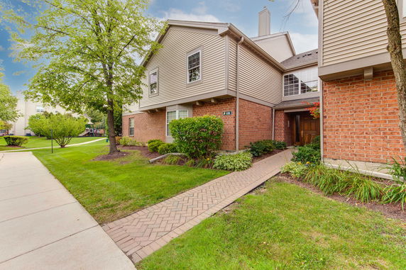 Front view of a two-story house with brick and siding exterior.