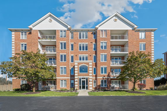 Front view of a multi-story building with brick façade and multiple balconies