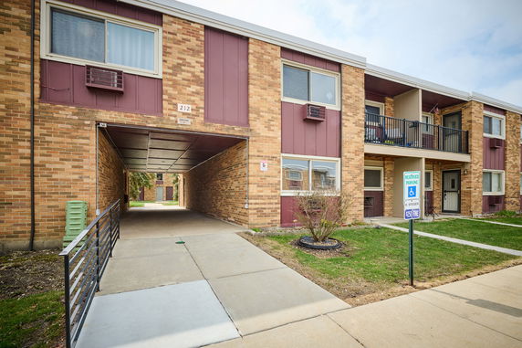 Front view of a two-story building with brick exterior and reserved parking.