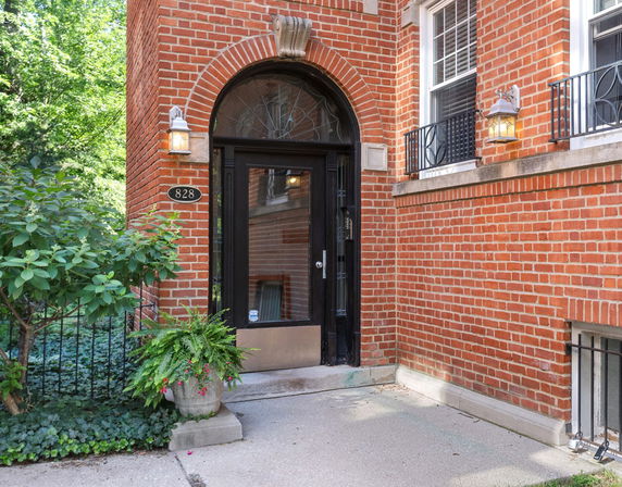 Front view of a brick building entrance with an arched doorway.