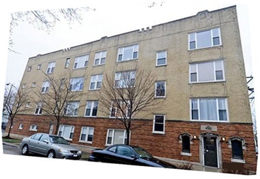 Front view of a multi-story apartment building with brick facade.