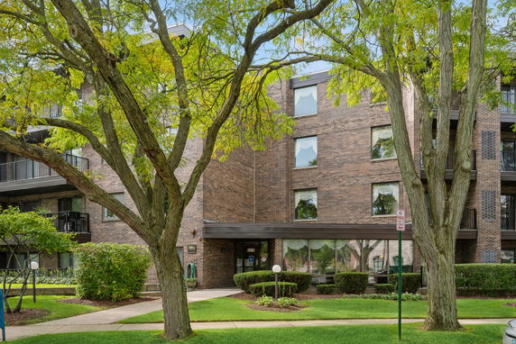 Front view of a multi-story brick building with a glass entrance.