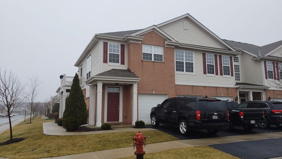 Front view of a two-story house with brick façade and attached garage.