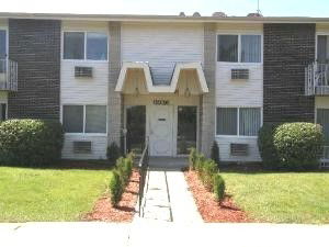 Front view of a two-story residential building with multiple windows and a central entrance.