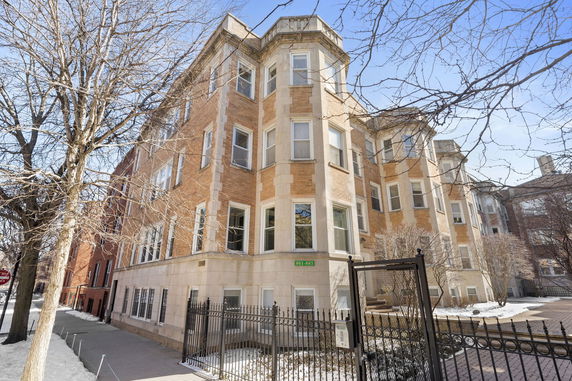 Front view of a multi-story brick building with numerous windows.