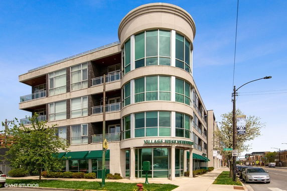 Front view of a multi-story building with large windows and a rounded corner design.