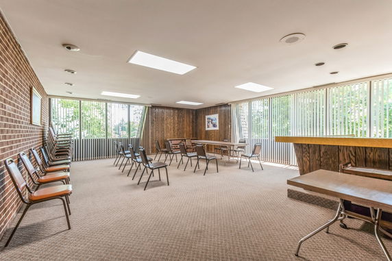 Spacious indoor area with chairs and tables arranged for meetings or events.