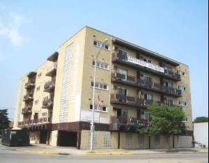 Front view of a multi-story apartment building with balconies.