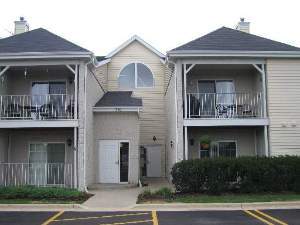 Front view of a two-story residential building with balconies and a central entrance.