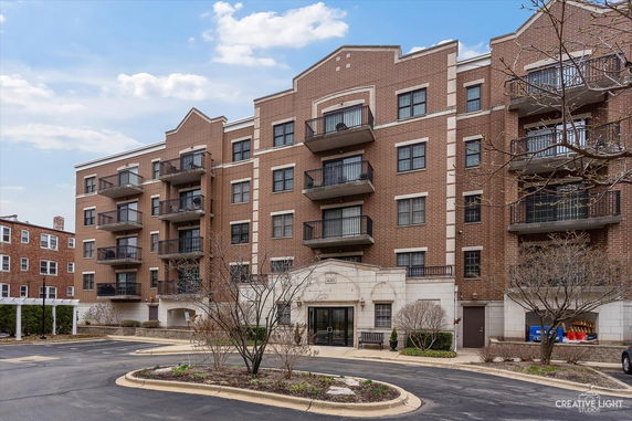 Front view of a multi-story brick apartment building with balconies.