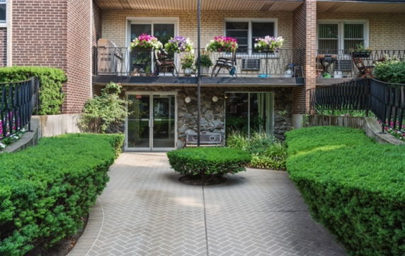Front view of a two-story building with balconies and sliding glass doors.