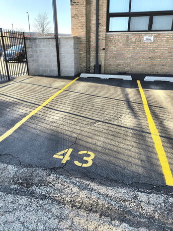 Numbered parking space in an outdoor area next to a brick building.