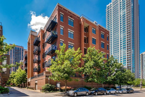 Front view of a mid-rise brick apartment building with balconies.