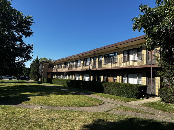 Front view of a two-story apartment building with balconies.
