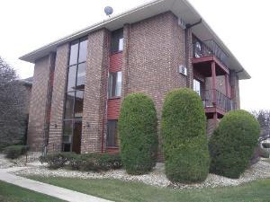 Front view of a multi-story brick building with large windows and balconies.