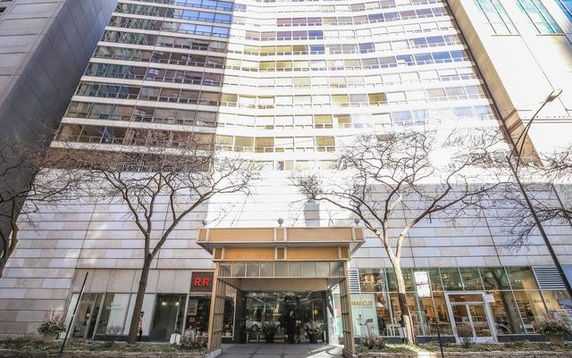 Front view of a multi-story building with large windows and commercial spaces on the ground floor.