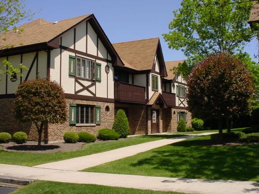 Front view of a two-story house with brick and half-timbered exterior design.