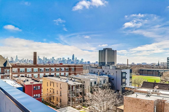 Panoramic view of an urban skyline with multiple buildings and a clear blue sky.