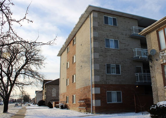 Front view of a multi-story apartment building with balconies.