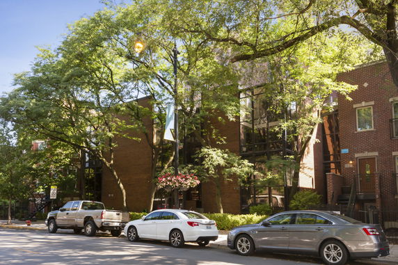 Front view of a multi-story residential building with glass and brick facade.