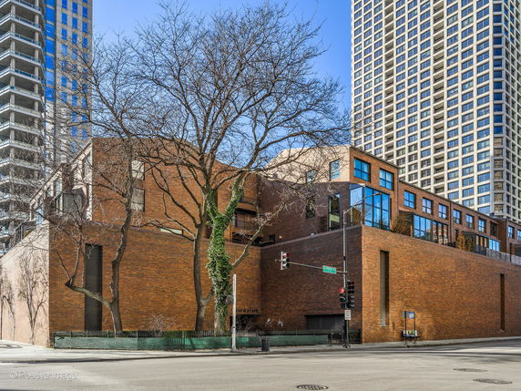 Front view of a multi-story brick building with large windows and a modern architectural design.