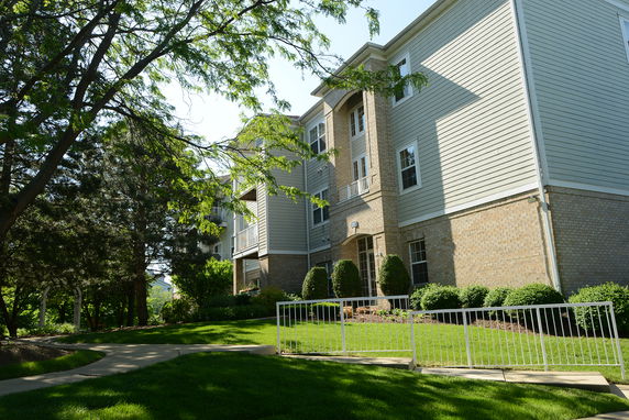Front view of a multi-story apartment building with brick and siding exterior.