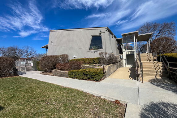 Front view of a modern building with an entrance and stairs.