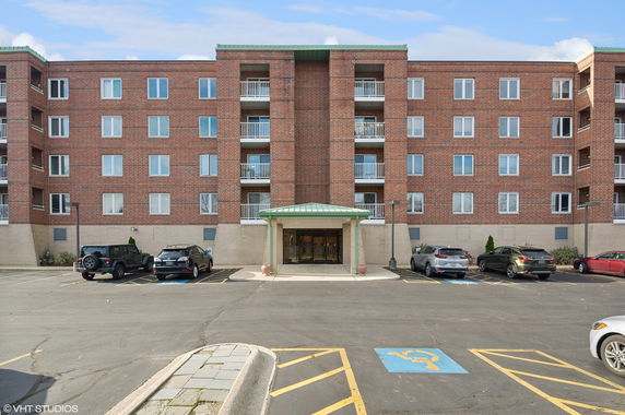 Front view of a multi-story brick building with balconies.
