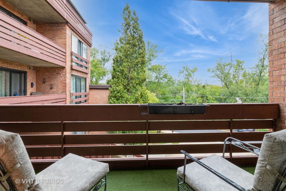 Balcony view overlooking surrounding trees and nearby buildings.