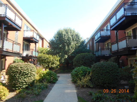 View between two residential buildings with balconies.