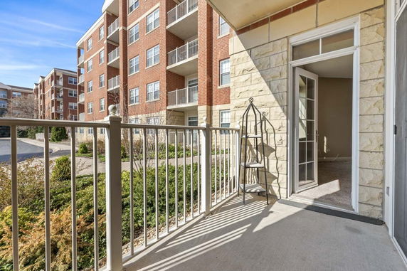 View from a balcony looking at apartment buildings with brick and stone exteriors.