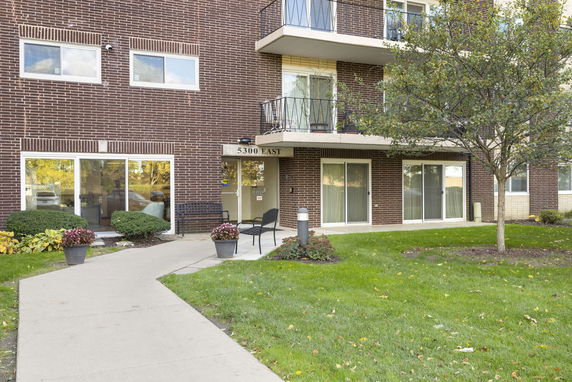 Front view of a brick apartment building with balconies and sliding glass doors.