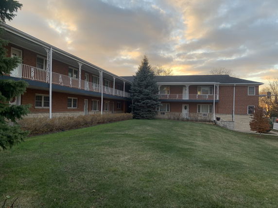 Front view of a two-story brick building with balconies.