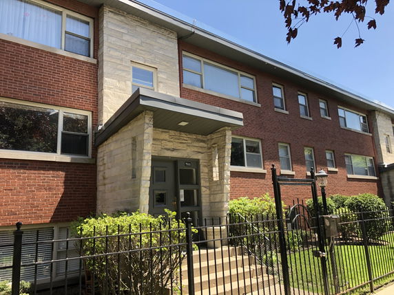 Front view of a multi-story brick apartment building.