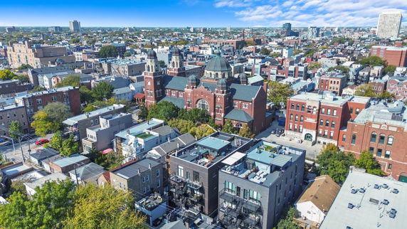 Aerial view of a cityscape with a prominent church building and surrounding residential and commercial structures.