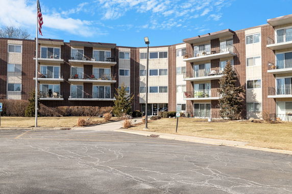 Front view of a multi-story apartment building with balconies.