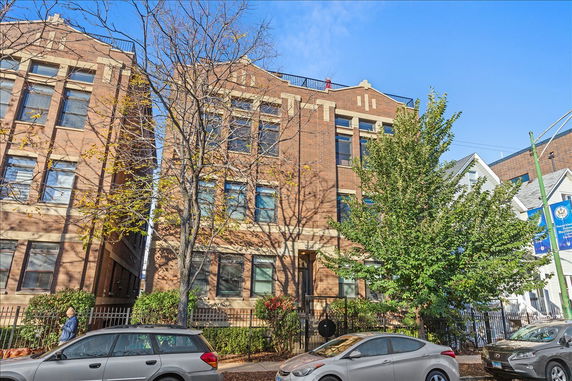 Front view of a multi-story brick building with large windows.