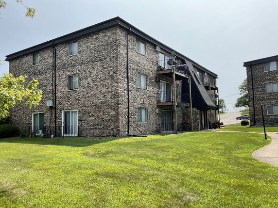 Front view of a multi-story brick apartment building.