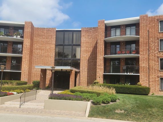 Front view of a multi-story brick building with balconies.