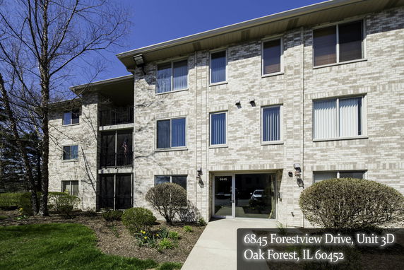 Front view of a three-story brick apartment building with multiple windows.
